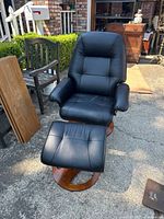 Front view of chair with ottoman on wooden base