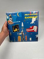 Front and side view of the sealed Jean-Michel Basquiat 1994 calendar showing artwork and title.