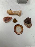 Overview of all six mineral specimens arranged on a white surface showing size and texture variety.