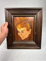 Frontal view of the vintage pop art painting showcasing the cartoon style portrait of a young boy with a dark wood frame and gold accent, slightly angled to show depth.