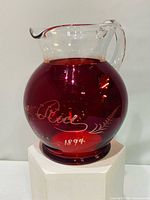 Front view showing engraving "Rosa Rice Fait" and date 1894 on red glass body