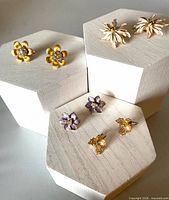Four pairs of clip earrings displayed on stands