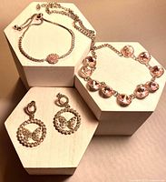 Front view of necklace, bracelet, and earrings on display blocks