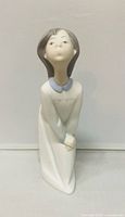 Front three-quarter view of Lladro girl blowing kiss figurine