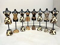 Group shot of all eight resin mini mannequins with animal prints
