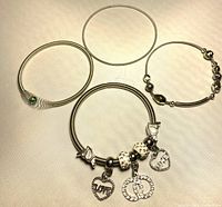 Group shot of four silver-tone spring coil bracelets laid out