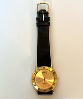 Front view of watch showing dial, bezel, and part of leather strap
