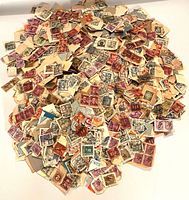 Pile of mixed canceled stamps on paper backing