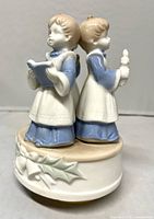 Front view showing two choir girls back-to-back on base with holly motif