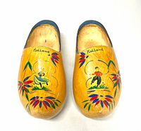 Top view showing painted figures, floral motifs and "Holland" text on each clog