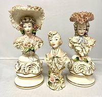 Front view of three porcelain lace bust figurines showing detailing and size comparison