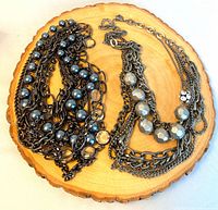 Both necklaces laid out showing chain styles and beads