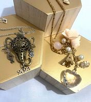 Both necklaces laid flat showing pendants and charms