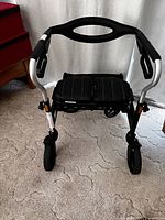 Front view of the black and silver Evolution walker with cushioned seat and padded handles