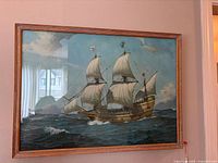 Framed nautical print of a sailing ship on the sea with detailed sails and rigging in a wooden frame.