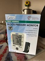 Boxed Option+ Easy Viewing Blood Pressure Monitor with details on features and display.