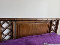Front view of queen size wooden headboard with carved panel and lattice design sides