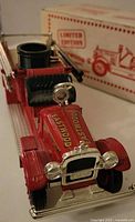 Close-up image of first vintage fire truck toy showing Good 5-10 Eastwood text on hood and front grill details, with original limited edition box in background.