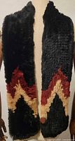 Full view of the black rabbit fur scarf with red and beige zigzag style pattern, draped on mannequin