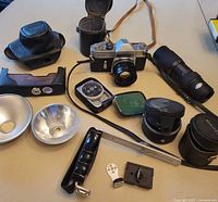 Full lot overview showing camera, lenses, cases, flash units, and accessories arranged on a table.