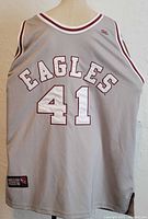 Back view of gray sleeveless basketball jersey with 'EAGLES' and number '41' printed, showing maroon and white trim details