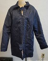 Front view of navy blue vintage Sears Wearmaster winter coat on mannequin, showing full length and zippered front.