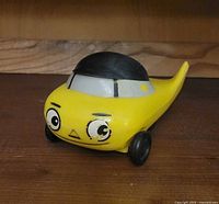 Front view of the yellow plastic vintage Mr. Beep BP Oil promotional car toy bottle opener with character face.