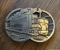 Front view of metal Kenworth King of the Road belt buckle showing a detailed relief of a truck and text.