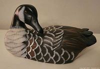 Front and side views of wood duck carving showing detailed feather painting and wood finish.