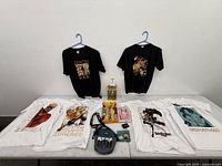 Overall lot layout showing T-shirts, figure box, accessories