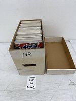 Short box filled with bagged comics, lid beside