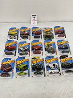 All 15 Hot Wheels cars arranged on table, showing sealed cards
