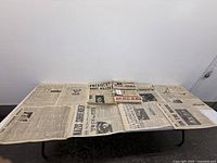 Entire set of laminated newspapers on table
