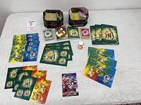 overview of entire lot including tins, cards, sticker sheets, figure and coin
