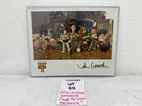 Full view of signed Toy Story 2 photo in sleeve with lot tag