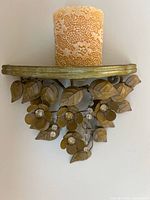 Metal wall sconce holding the decorative candle, showing floral metalwork and crystal accents