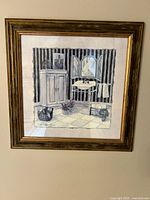 Framed wall art showing a bathroom interior with striped wallpaper, cabinet, sink with mirror and towel, basket with plants, and tiled floor.