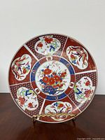 Front view of the porcelain plate showing the colorful Imari style floral and phoenix design in multiple colors including red, blue, gold, green, and orange.