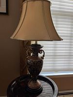 Full view of table lamp with shade in natural light, showing overall shape and color.