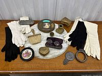 Full lot on marble tabletop showing opera gloves, framed cameo, trinket boxes, eyeglasses, and various small items