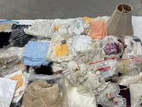 Overview of the assorted lace and fabric trims with the beige lace lampshade in the upper right corner