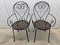 Both wrought iron chairs side by side showing heart-shaped backs and woven seats with rust spots
