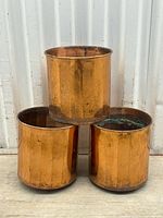 Three copper planters stacked in a triangle formation showing overall size and condition.