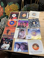 Twelve of the singles laid out on tabletop showing sleeves and labels