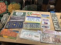 Overview of all thirteen license plates on table