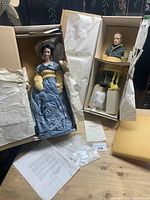 Both dolls in original boxes with packing and certificates visible