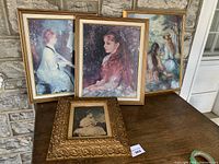 Four framed prints on table