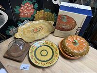 Group shot showing all four items: pumpkin pie keeper, boxed, teak cake tray, rectangular platter, round French plate