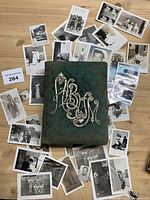 Album surrounded by loose black-and-white photographs