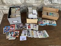 Three boxes and spread stacks of assorted trading cards on table